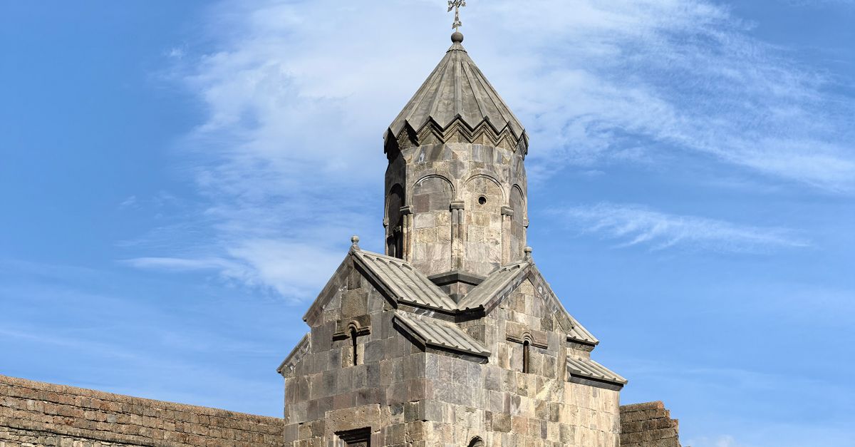 Historic medieval church in Tatev, Armenia under clear blue skies.