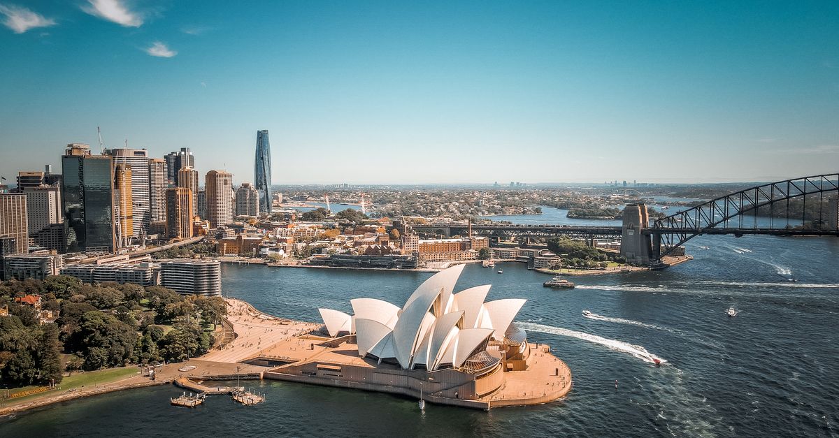 Breathtaking aerial view of Sydney Opera House with surrounding skyline and Harbor Bridge.