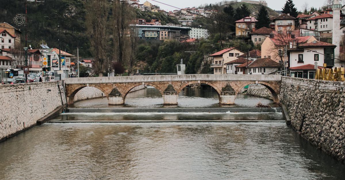 Scenic view of a historic stone bridge over the Miljacka River in Sarajevo, Bosnia and Herzegovina.