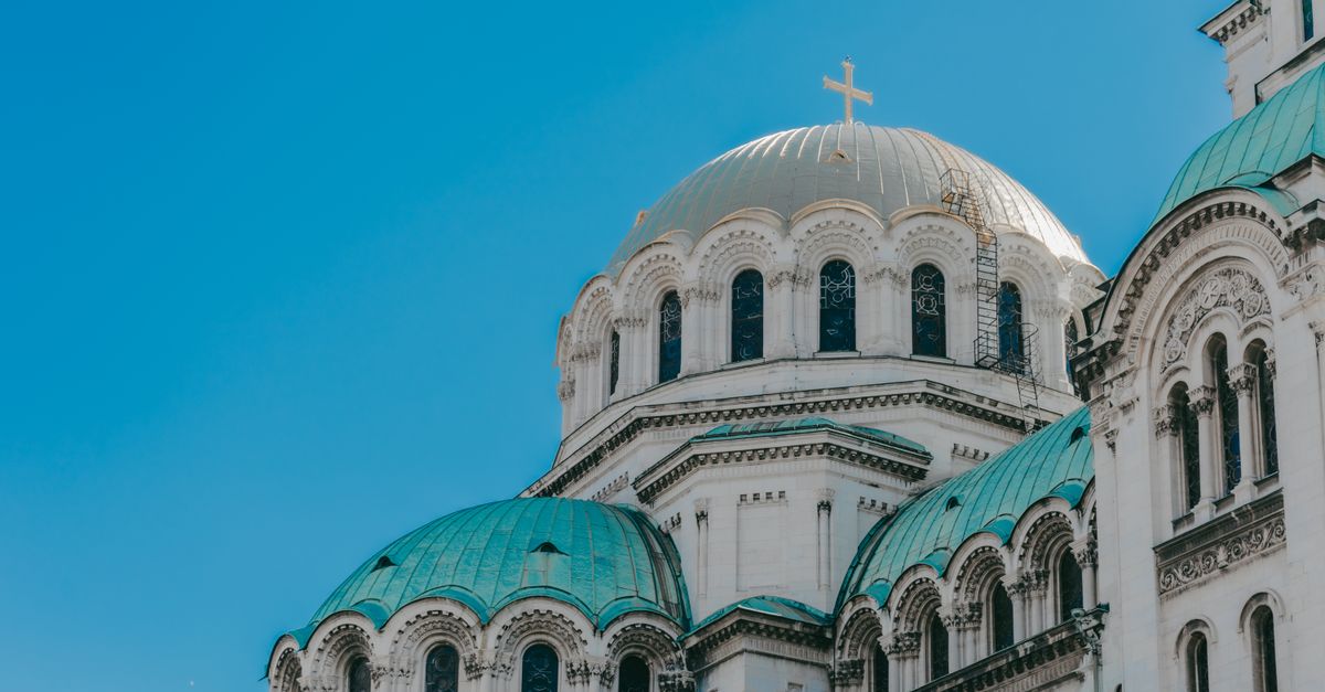 The iconic domes of Alexander Nevsky Cathedral against a clear blue sky in Sofia, Bulgaria.
