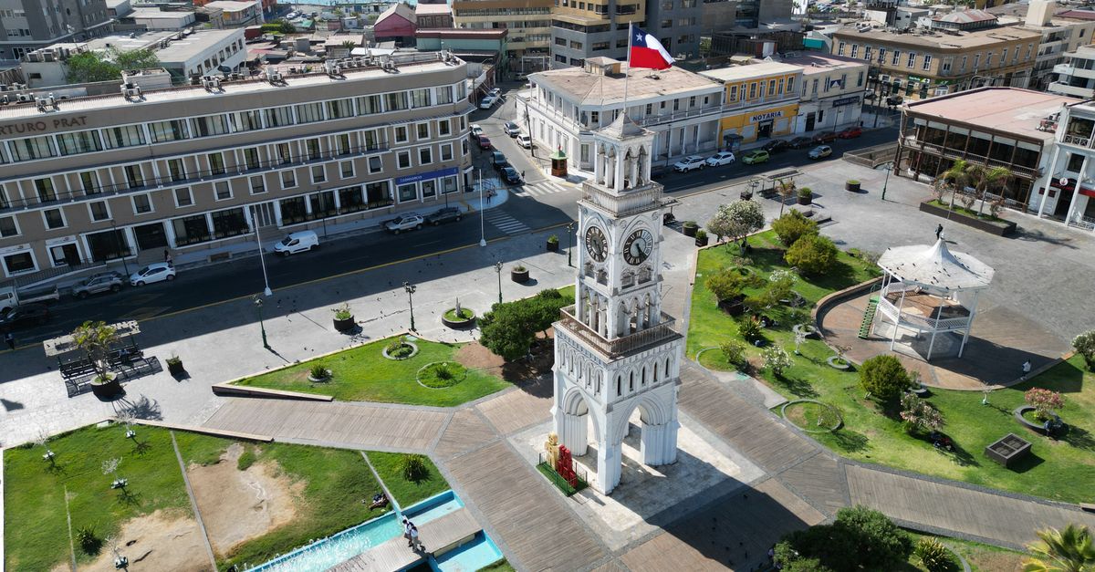 A stunning aerial view of the Clock Tower in Plaza Prat, Iquique, Chile, showcasing urban architecture and coastal beauty.