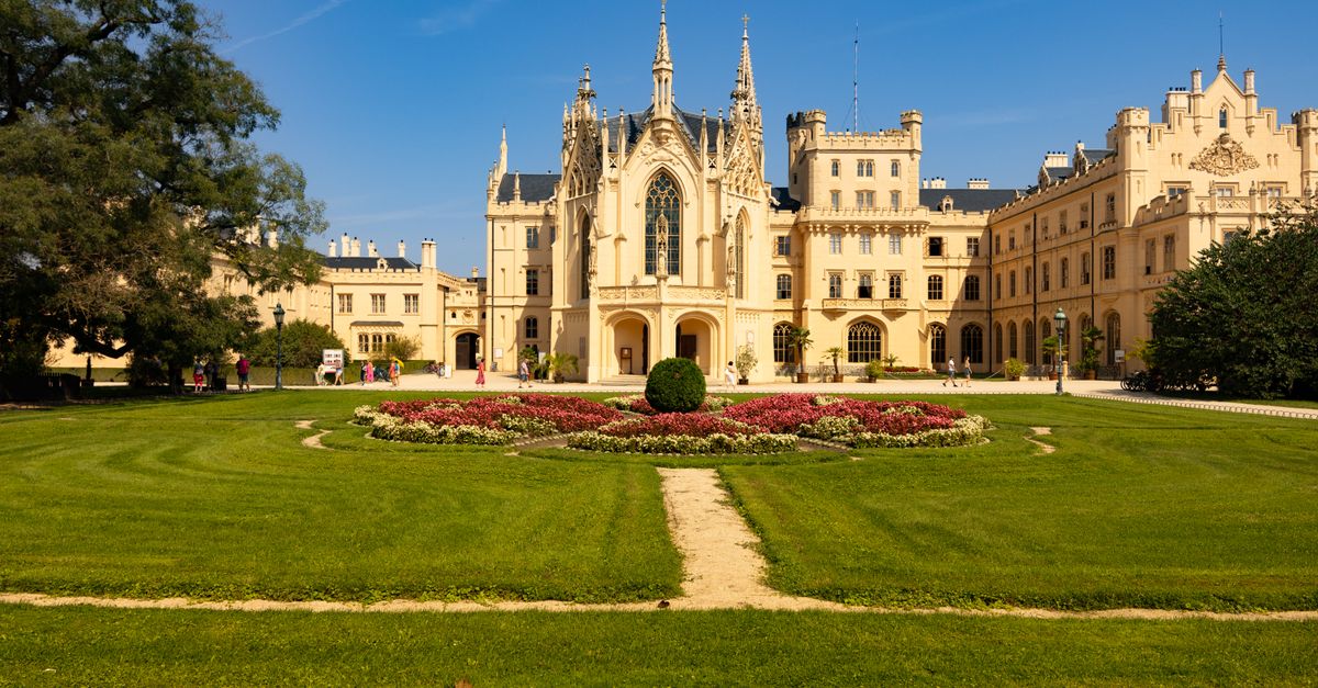 Beautiful Lednice Castle in the Czech Republic surrounded by lush gardens and a clear blue sky.