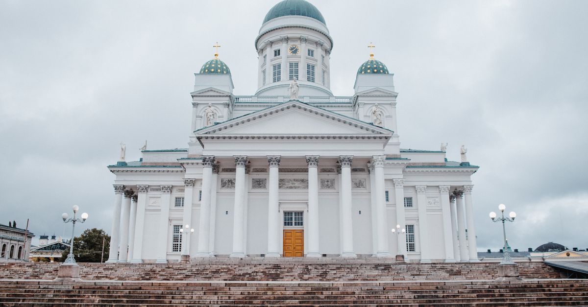 A frontal view of the iconic Helsinki Cathedral featuring neoclassical architecture under a cloudy sky.