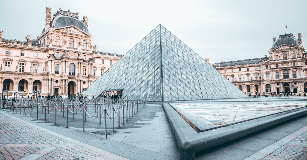 Iconic Louvre Pyramid in Paris, showcasing classic and modern architecture.