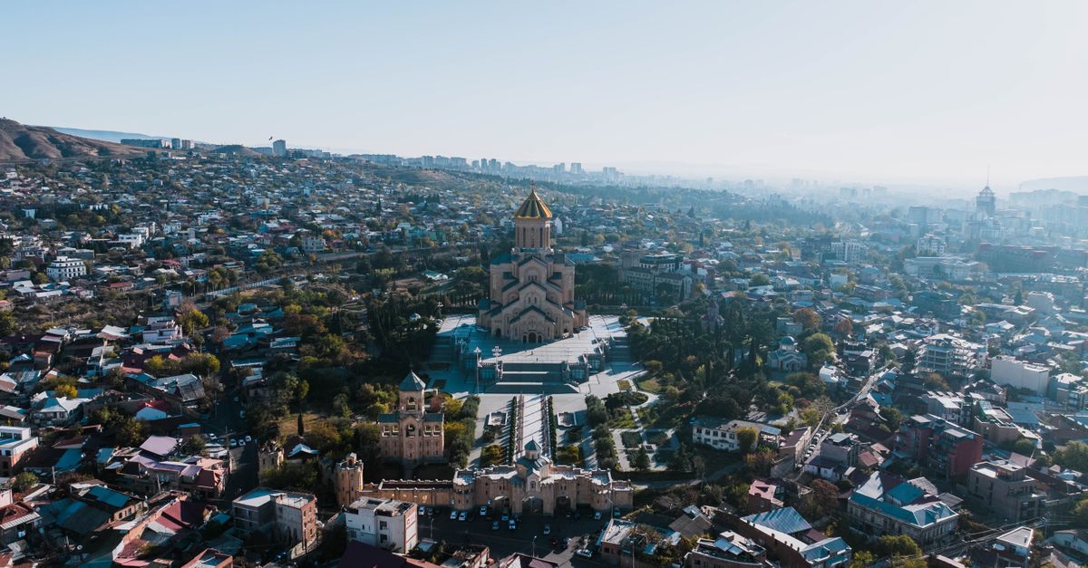 A stunning aerial view capturing the Holy Trinity Cathedral amidst the cityscape of Tbilisi, Georgia.