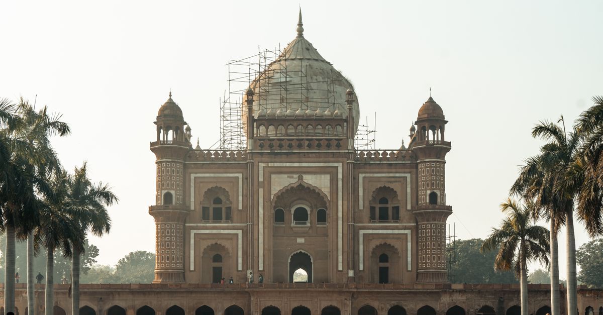 Front view of the iconic Safdarjung Tomb in New Delhi, surrounded by palm trees.