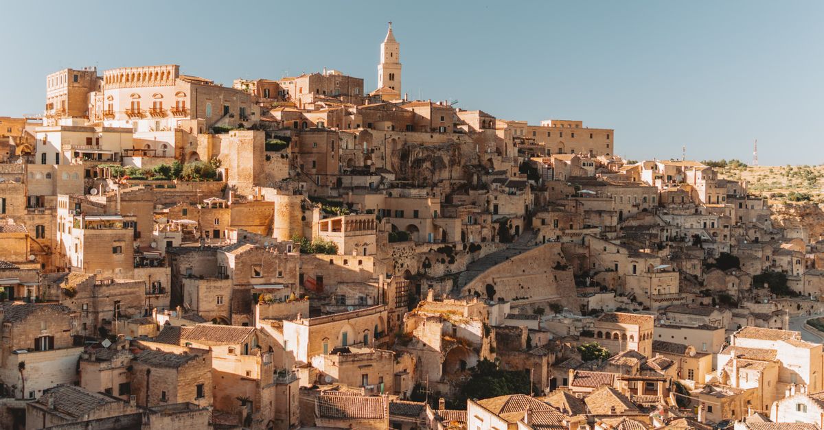 Explore the ancient stone dwellings of Matera, Italy, a UNESCO World Heritage site bathed in golden light.