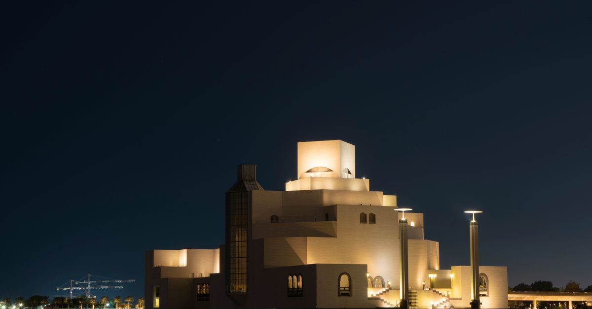 Stunning view of the illuminated Museum of Islamic Art in Doha, Qatar, captured under a clear night sky.