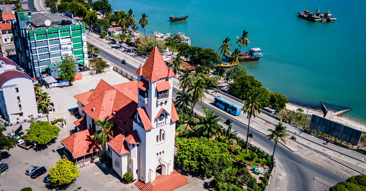 Aerial photograph of Dar es Salaam featuring a church near the coastline under a clear blue sky.