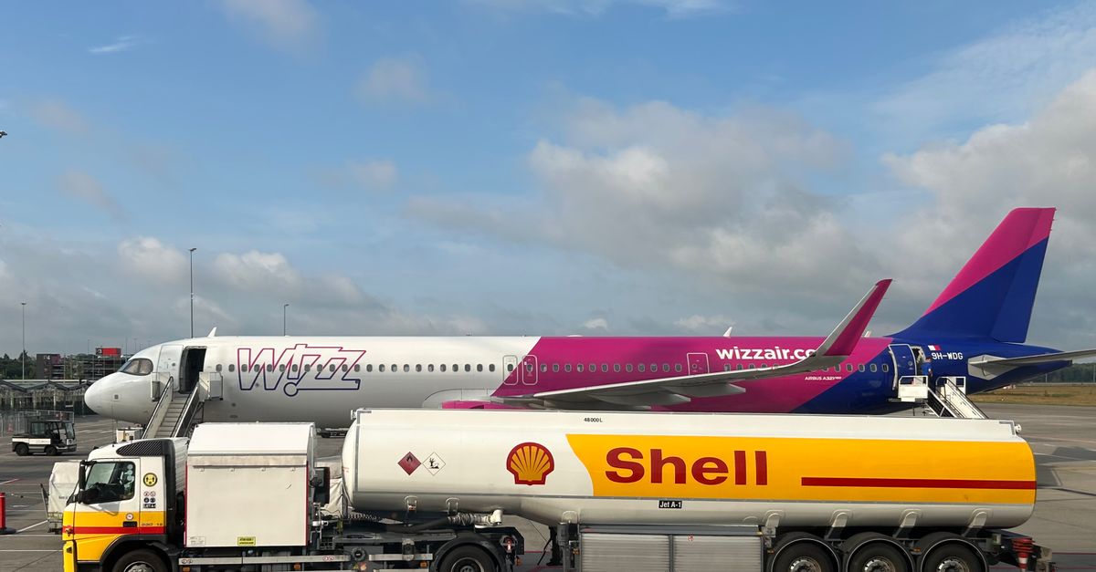 A plane being refueled by a Shell fuel truck on a sunny day at the airport.