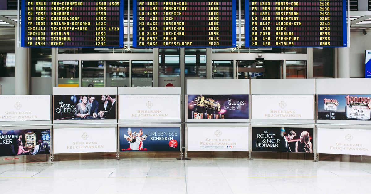 Electronic displays showing flight arrivals at Nuremberg Airport terminal.