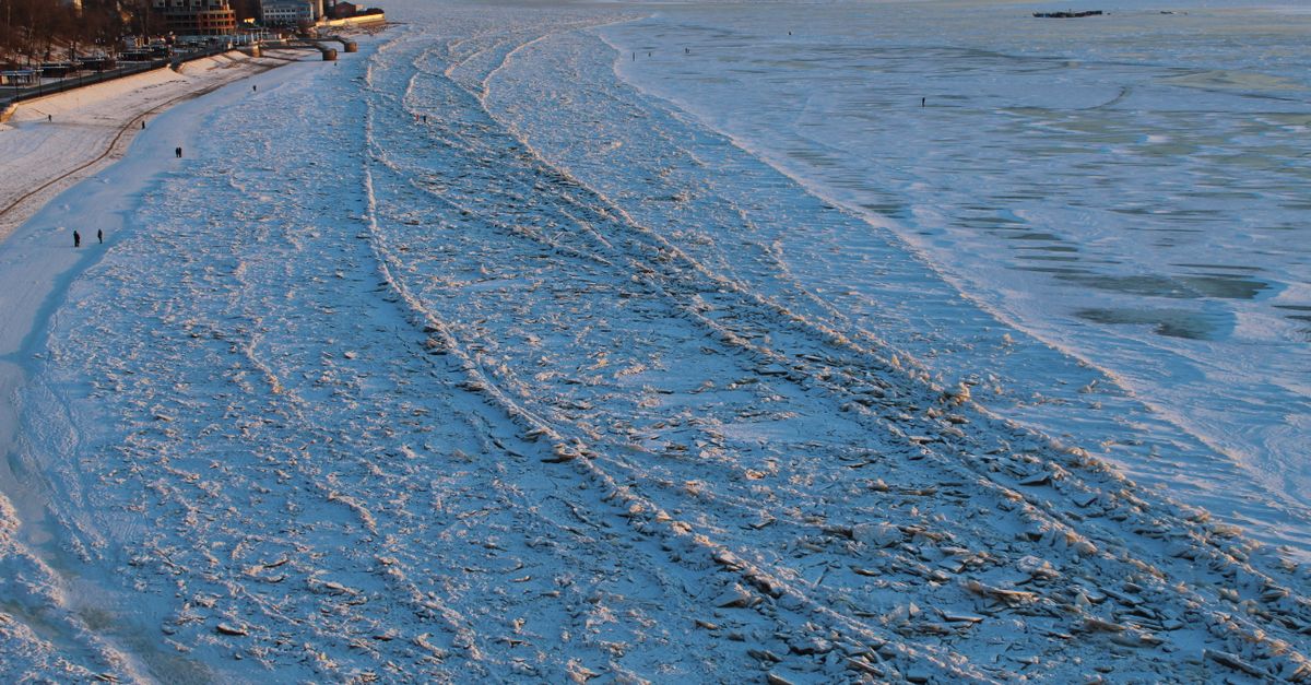 A stunning aerial view of a frozen riverbank in Khabarovsk, Russia, during winter sunset.