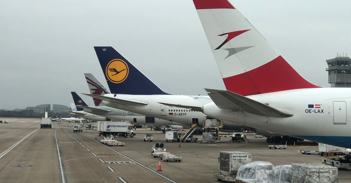 Airplanes parked at Dulles Airport with visible airline logos on a cloudy day.