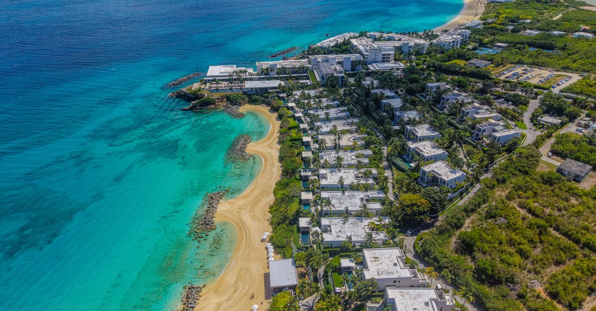 A breathtaking aerial shot showcasing the coastline and luxury resorts of Anguilla with turquoise waters.