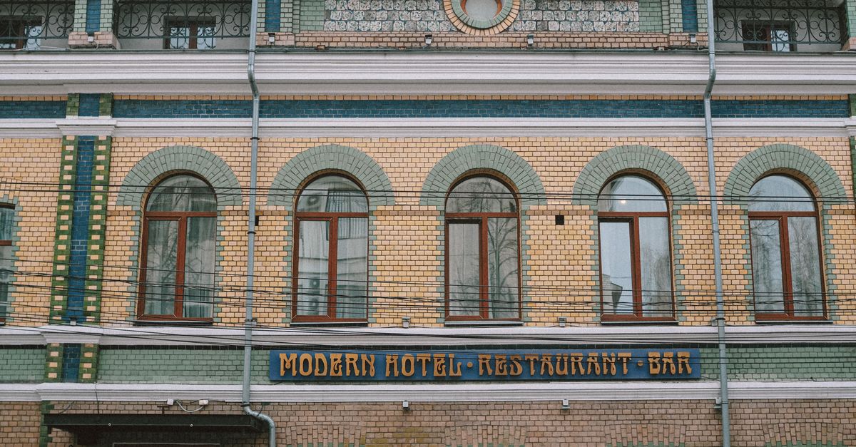 Historic building facade with arched windows and 'Modern Hotel Restaurant Bar' sign.