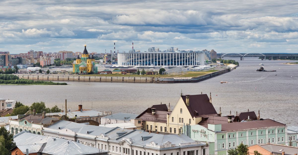 Aerial view of Nizhny Novgorod featuring the Volga River, historical buildings, and modern architecture under a cloudy sky.