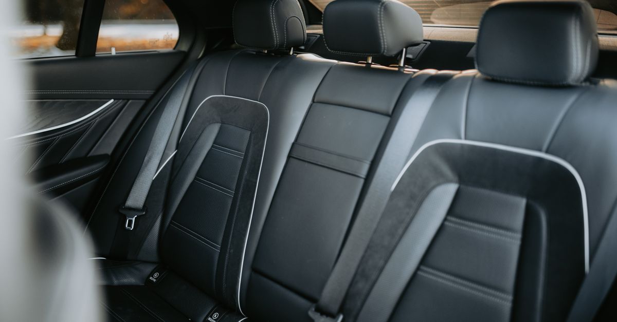 Elegant black leather car interior showcasing spacious and luxurious backseat design.