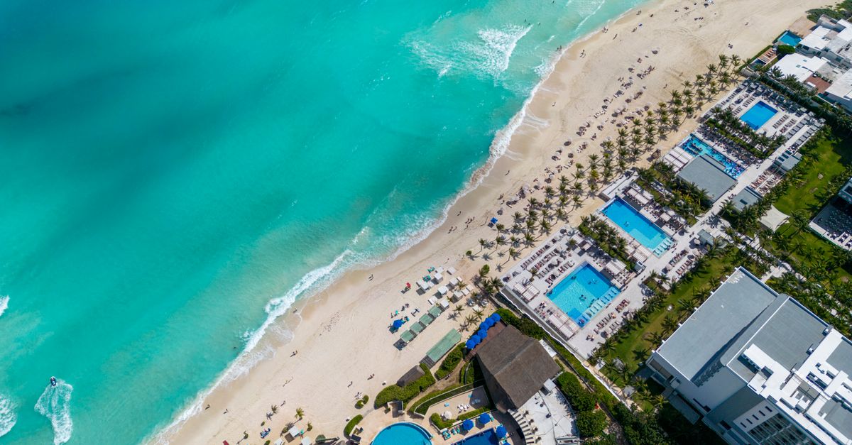 Stunning top view of a Cancun beach resort with turquoise water and sandy shore.