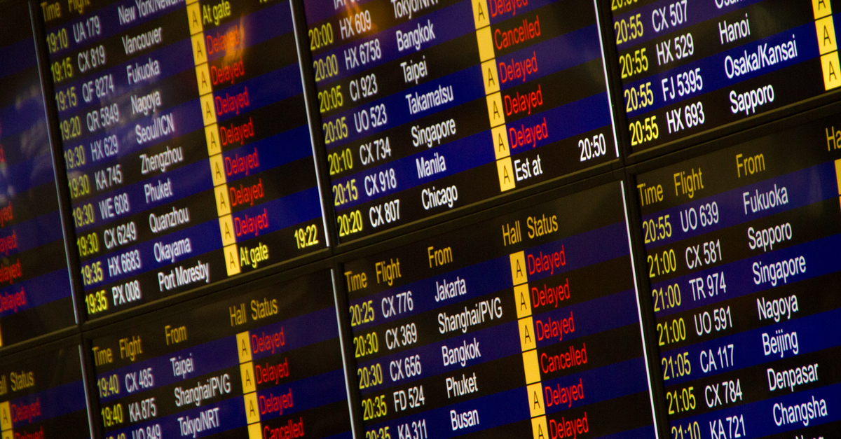 Close-up of digital flight information board showing arrivals and departures at an airport.