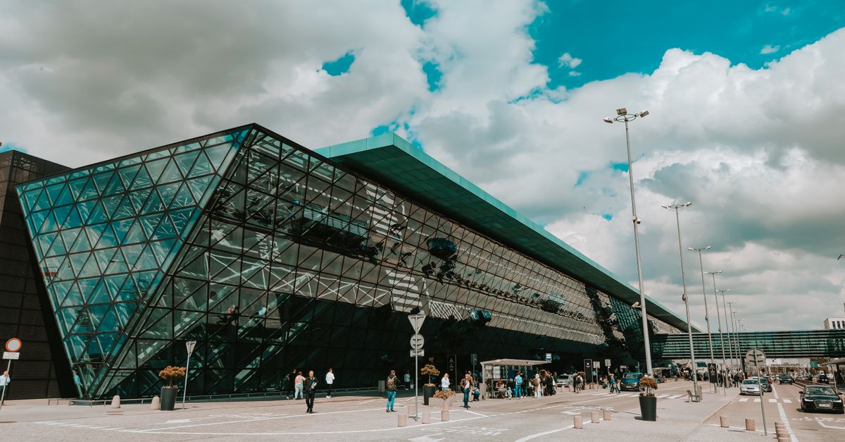 Contemporary airport terminal featuring striking glass facade under a cloudy sky.