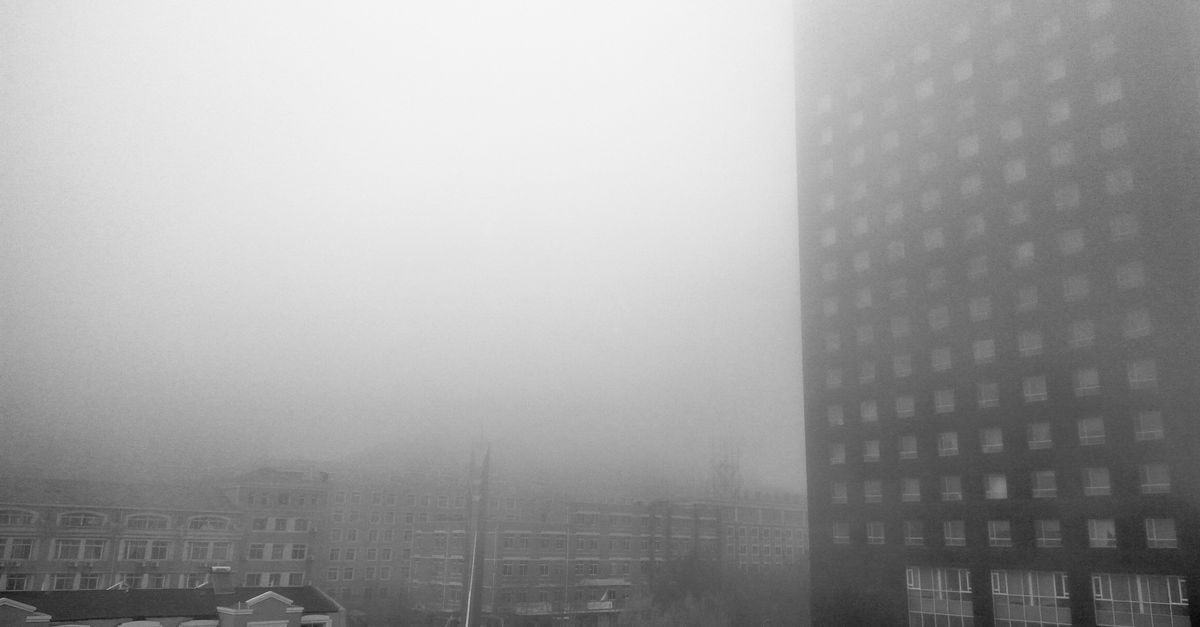 Foggy urban landscape with buildings and stairway in Dalian, China.