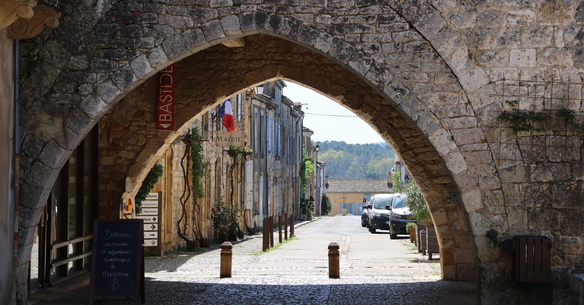 Charming European town with stone archway and vintage architecture.