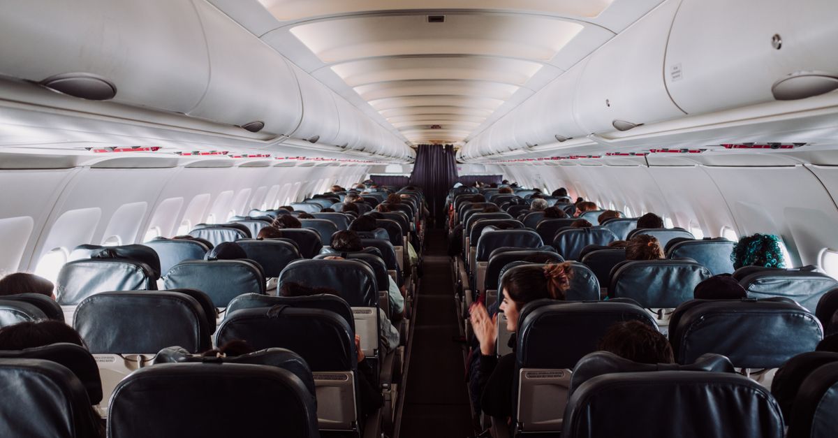 A view of passengers seated inside a commercial airplane cabin during flight.