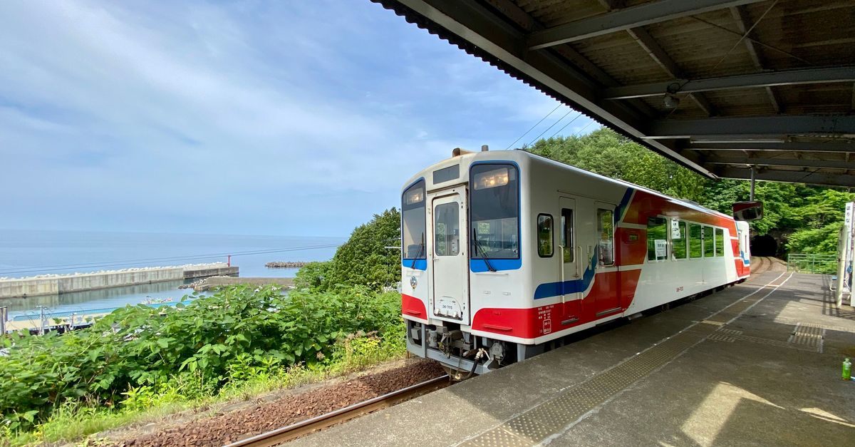 Colorful train at Fudai Station, Iwate, Japan with coastal view.