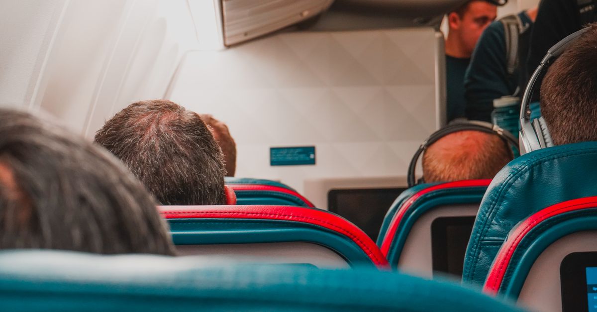 Interior view of an airplane cabin with passengers seated, focusing on seats and layout.