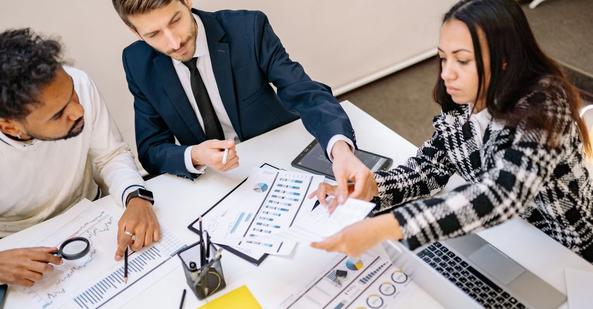 Business professionals engaging in a collaborative meeting with charts and documents.