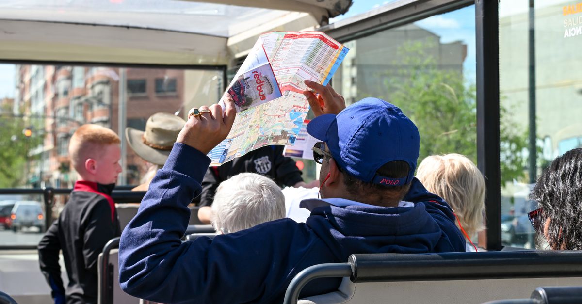 Tourists explore Valencia on an open-top bus tour, highlighting city sights and attractions.