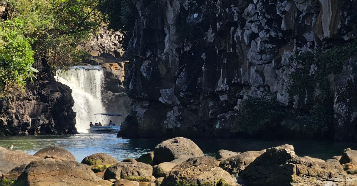 Explore the beautiful waterfall surrounded by rugged rocks and lush greenery in Mauritius.