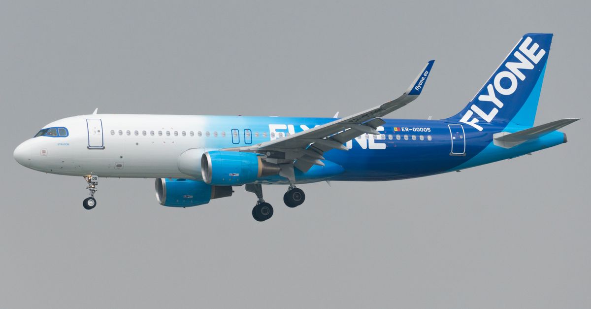 FlyOne Airbus A320 jet in flight, showcasing branding on a clear day.