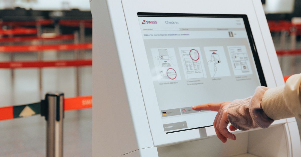 Passenger using self-service check-in kiosk at airport for convenient travel experience.