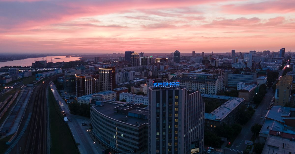 Stunning aerial view of Novosibirsk city skyline under a vibrant sunset sky.