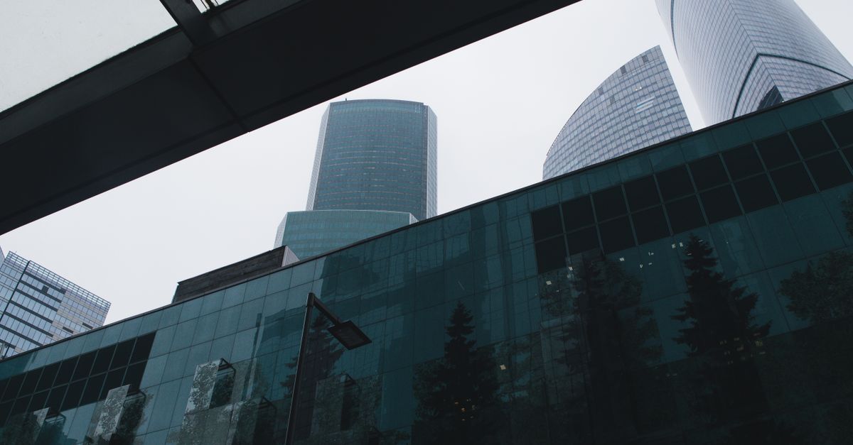 Low angle shot of modern glass skyscrapers in Moscow under a cloudy sky.