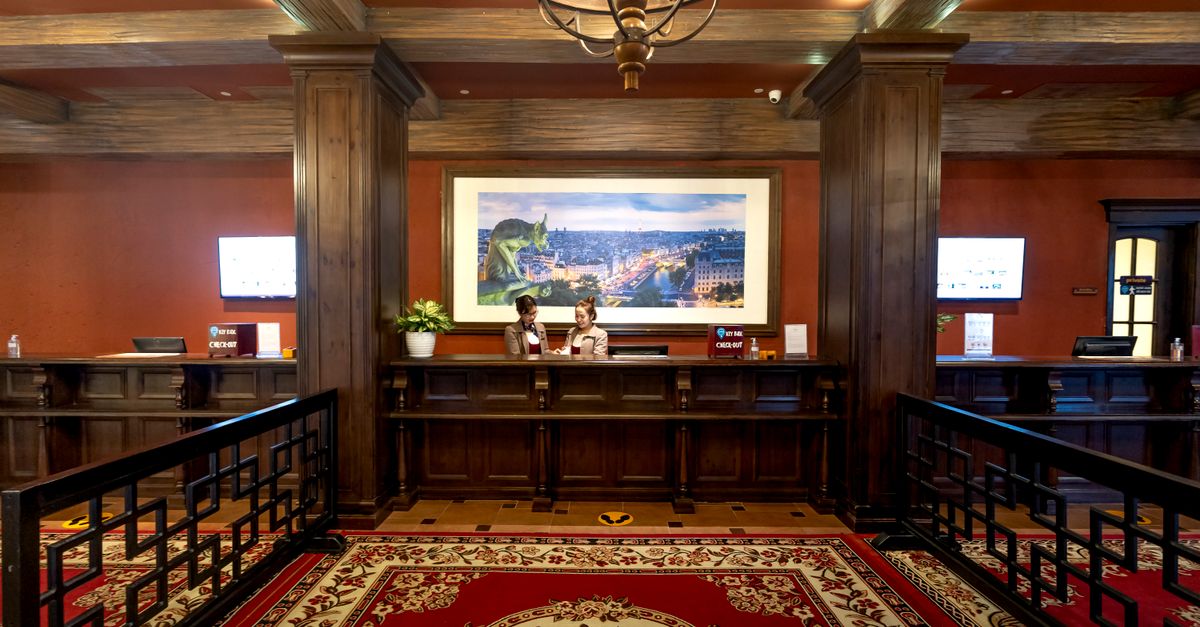 Elegant and luxurious hotel reception with classic wooden design and plush carpeting.