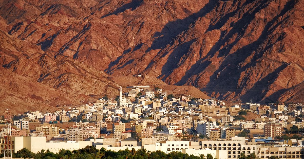A scenic view of Aqaba city framed by stunning red mountains. Captivating urban scenery.
