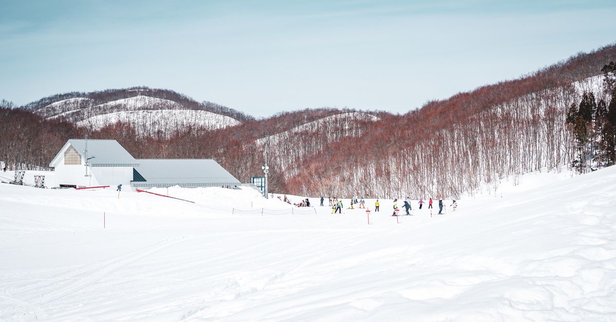 Winter scene at Yuzawa ski resort in Japan with snow-covered slopes and skiers enjoying the day.