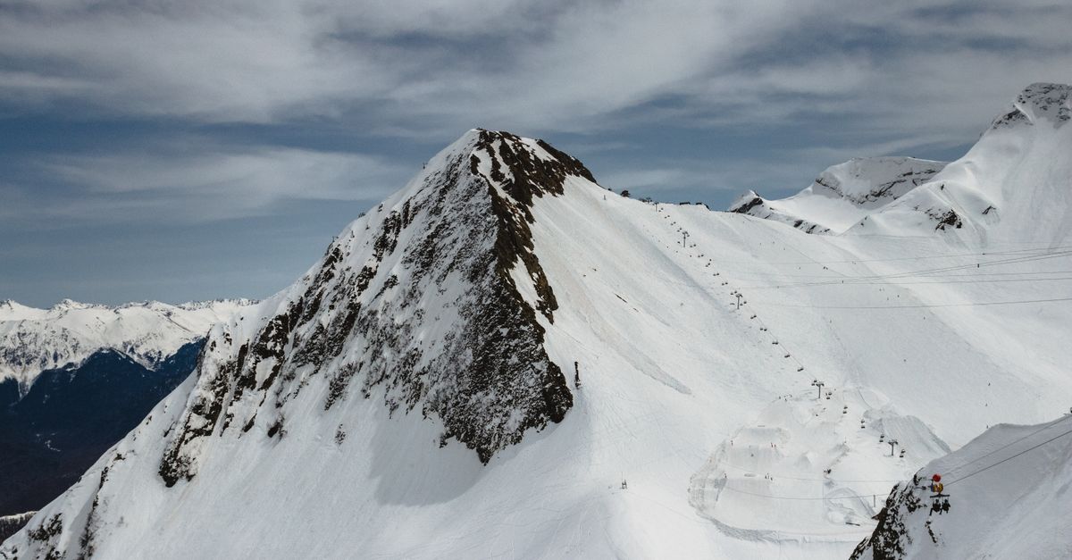 Breathtaking aerial view of snow-covered mountain peaks in Krasnaya Polyana, Russia during winter.