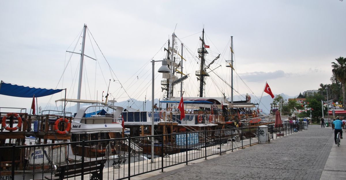 Scenic view of boats docked along the Antalya harbor promenade in Turkey during the day.
