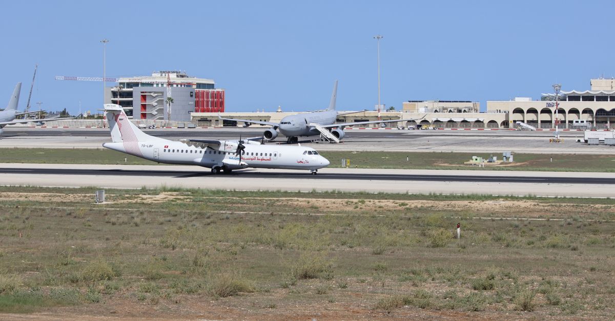 A commercial airplane preparing for takeoff on a sunny day at the airport.