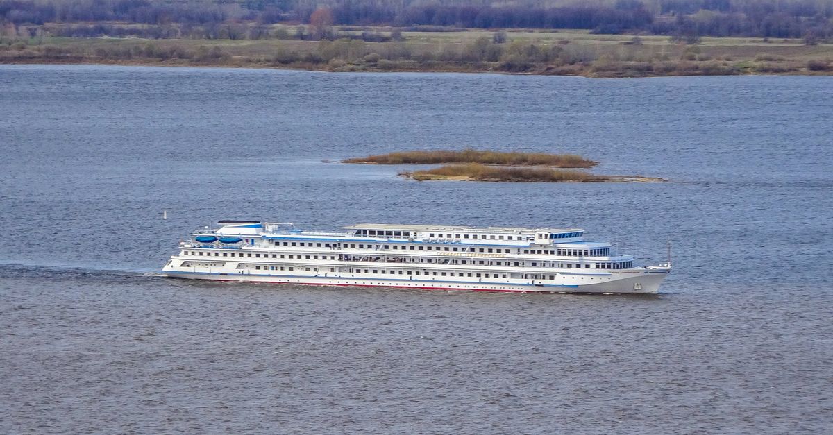 A large cruise ship sails on the Volga River near Nizhny Novgorod, Russia, showcasing tranquil travel.