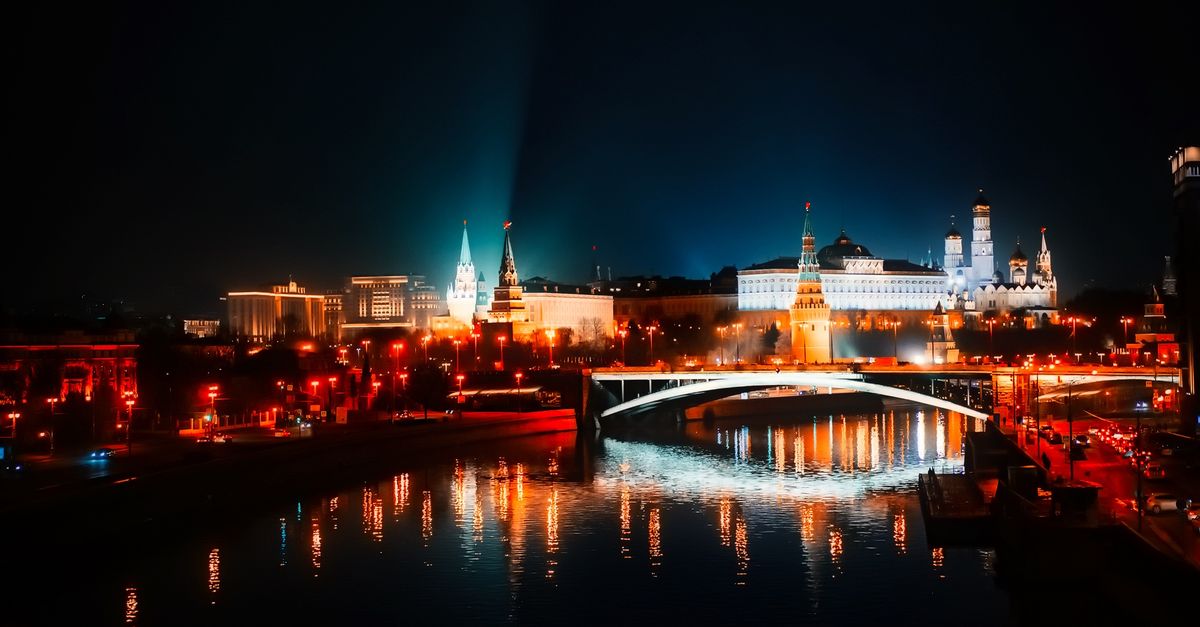 Stunning night view of Moscow's illuminated skyline with reflections on the river.