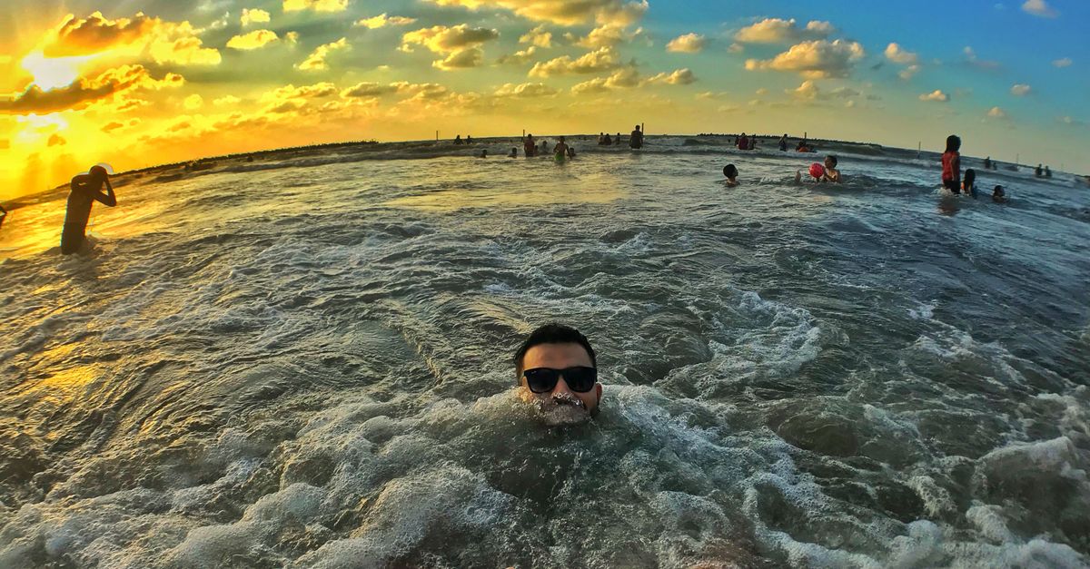 People enjoying a sunset swim at Ras El-Bar Beach, Egypt.