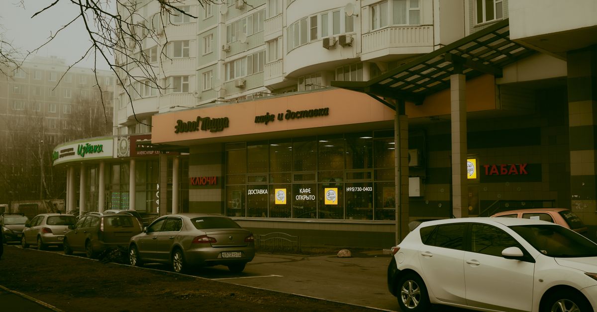 Street view in Moscow showcasing parked cars and commercial buildings.