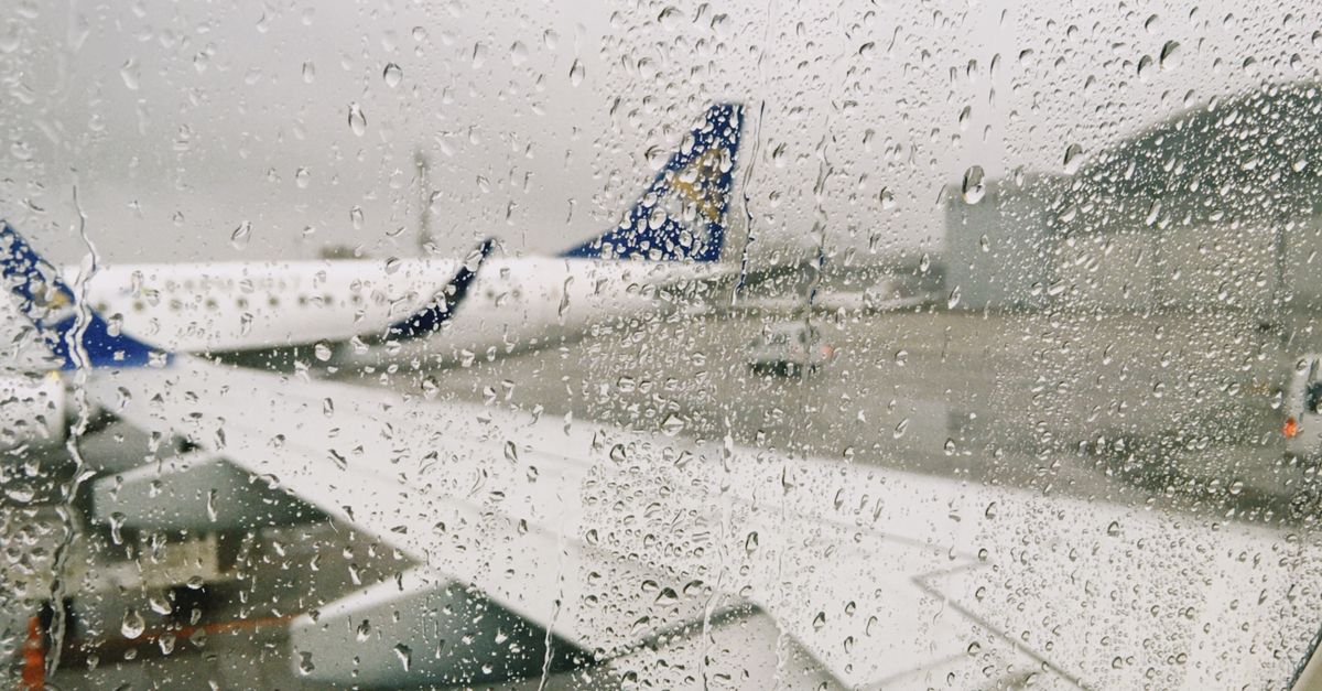 Raindrops on airplane window with a view of the airport in Almaty, Kazakhstan.