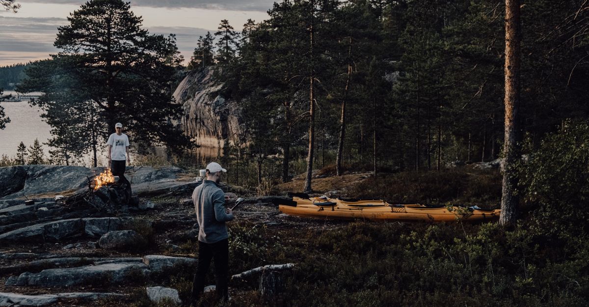 Two men camping and kayaking in the forested Ruskeala, Karelia, Russia.