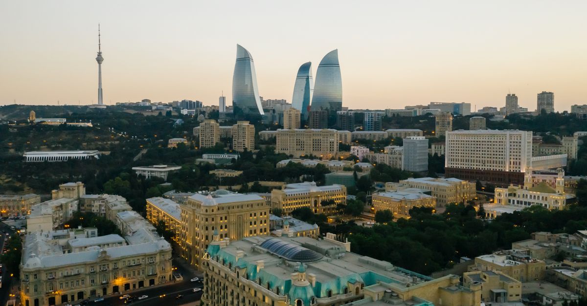 Aerial view of Baku cityscape showcasing the iconic Flame Towers with a vibrant sunset backdrop.