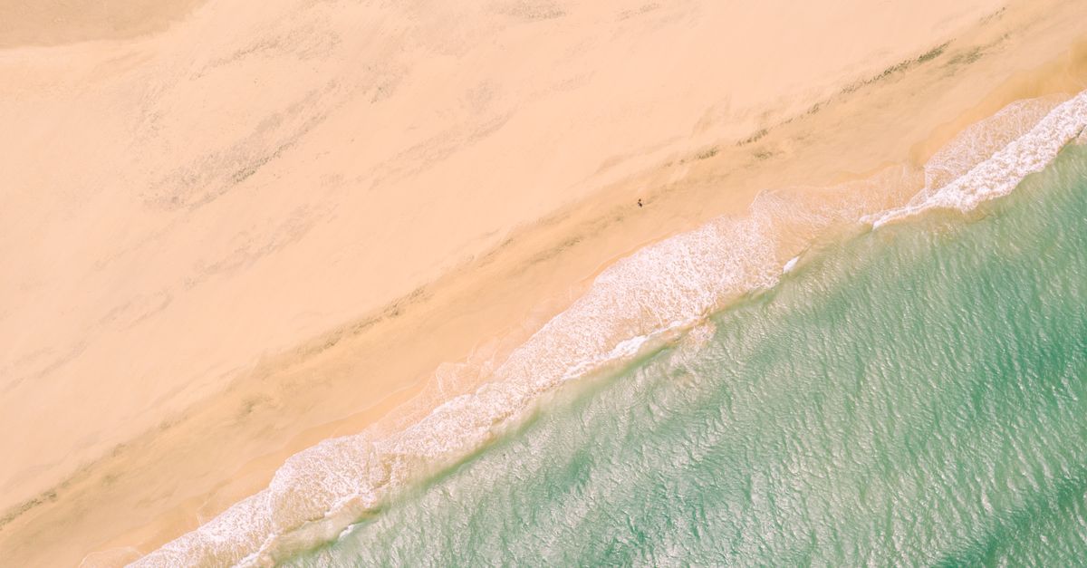 A stunning aerial view of the sandy beach and turquoise ocean in El Cotillo, perfect for coastal scenery and nature admiration.